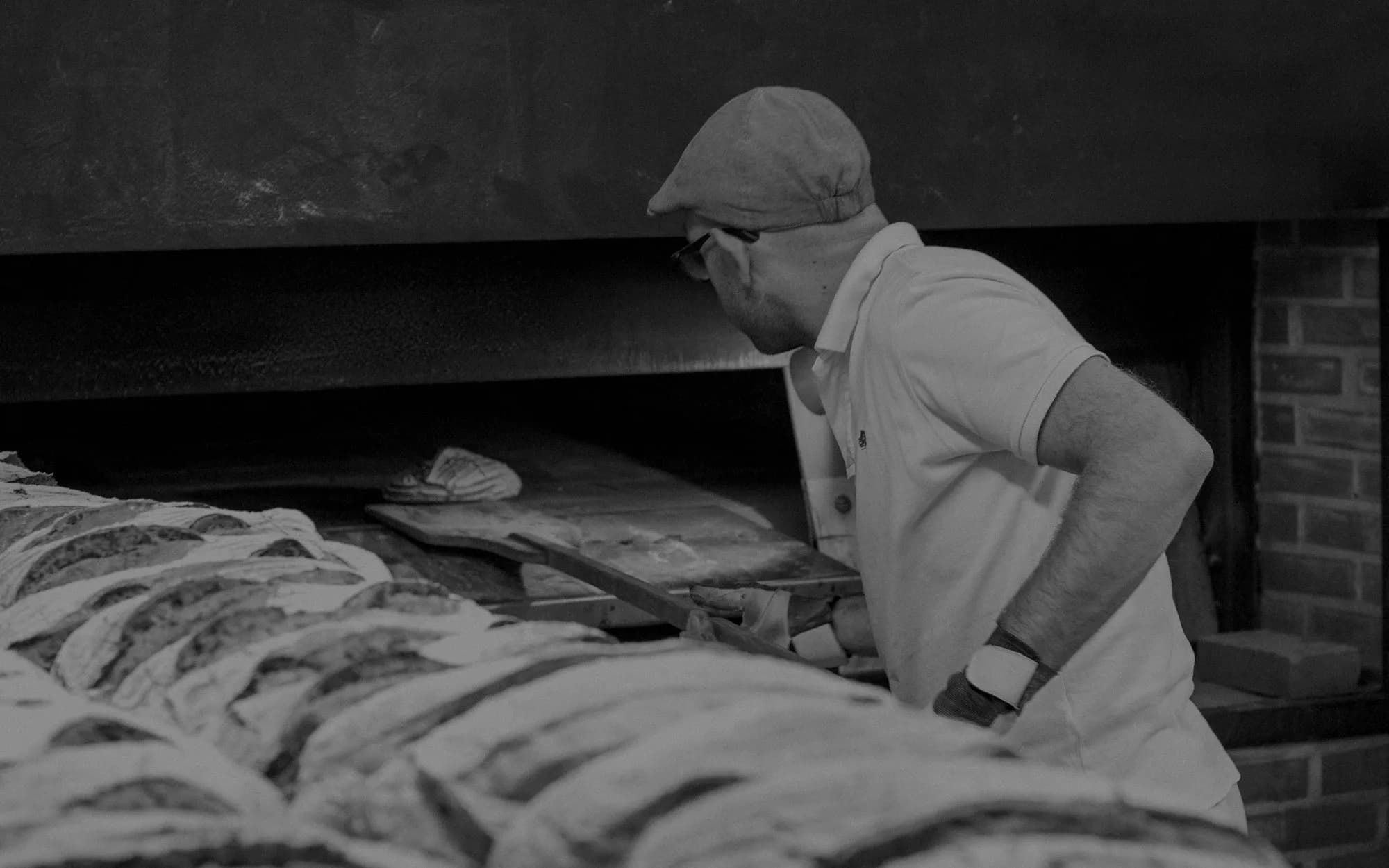 Panadero introduciendo pan en el horno de su obrador